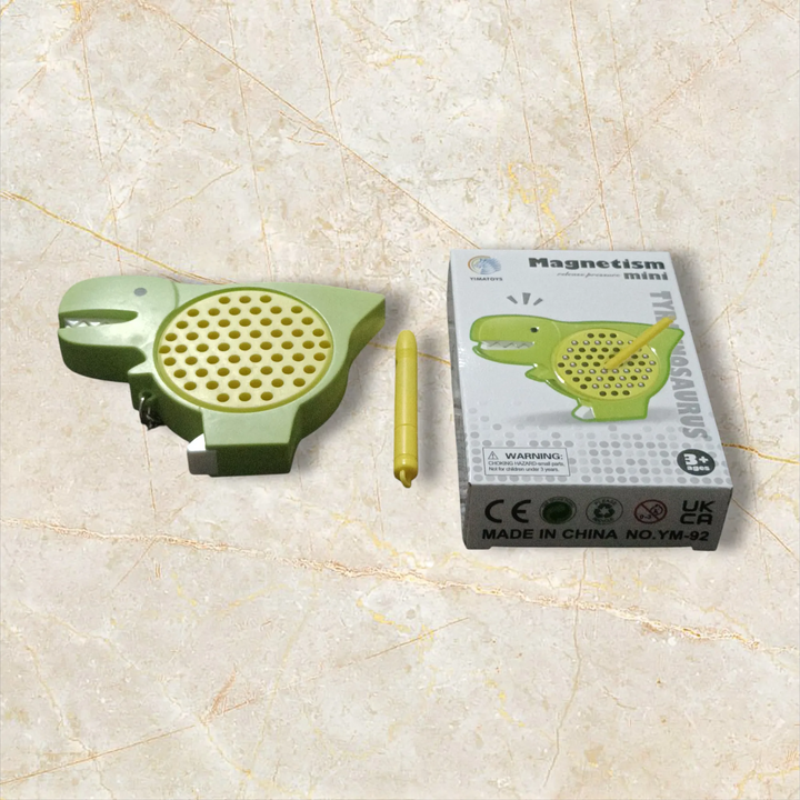 Green dinosaur-shaped magnet with packaging on a beige surface